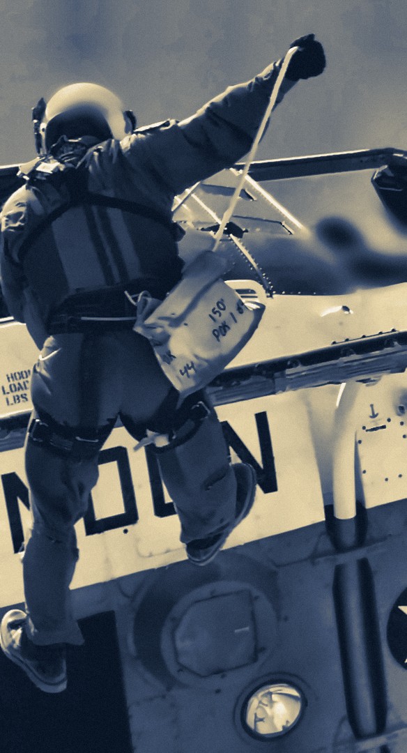A search and rescue corpsman stepping out on the rope from a Marines rescue helicopter